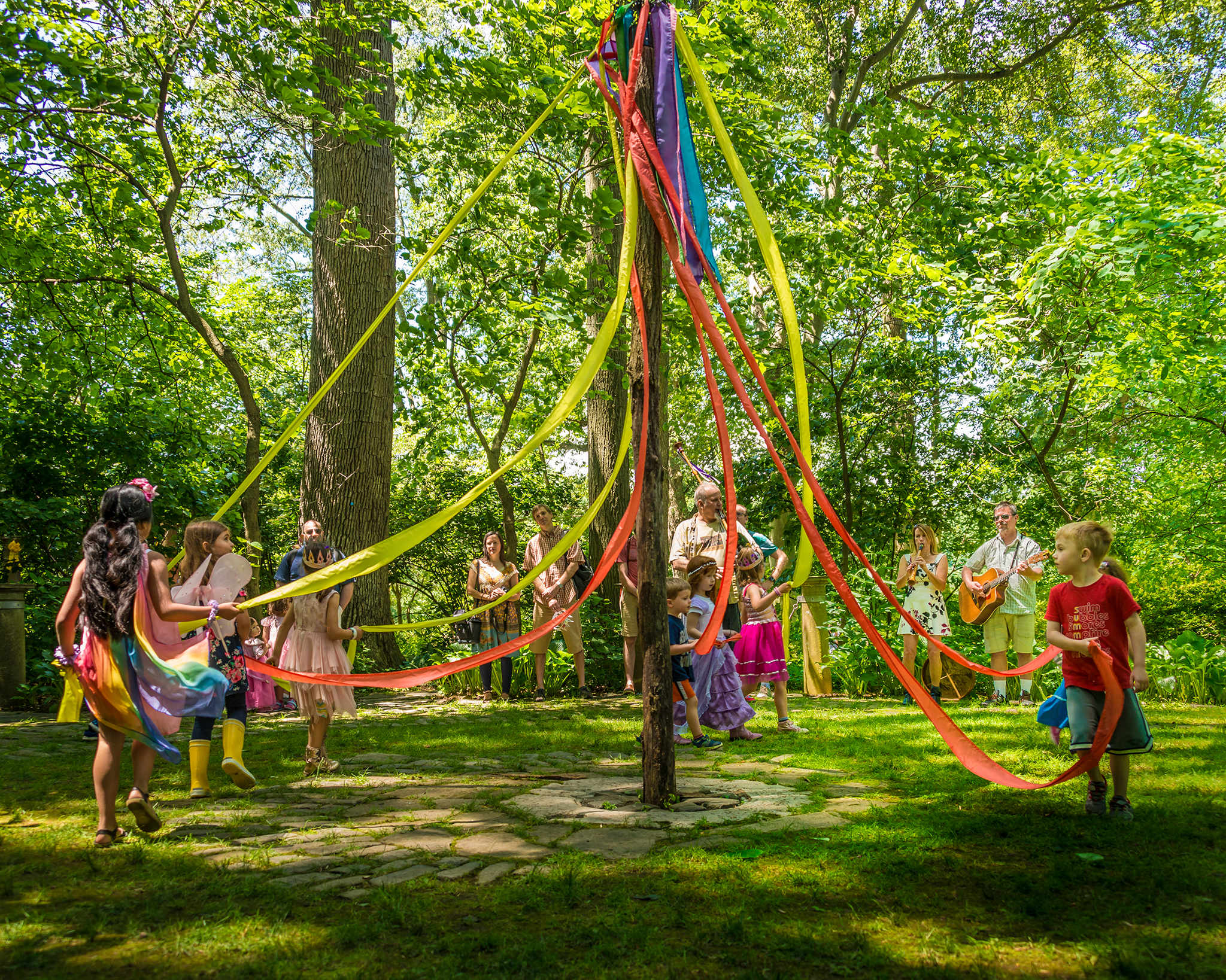 Children dancing around a maypole in the Enchanted Woods.